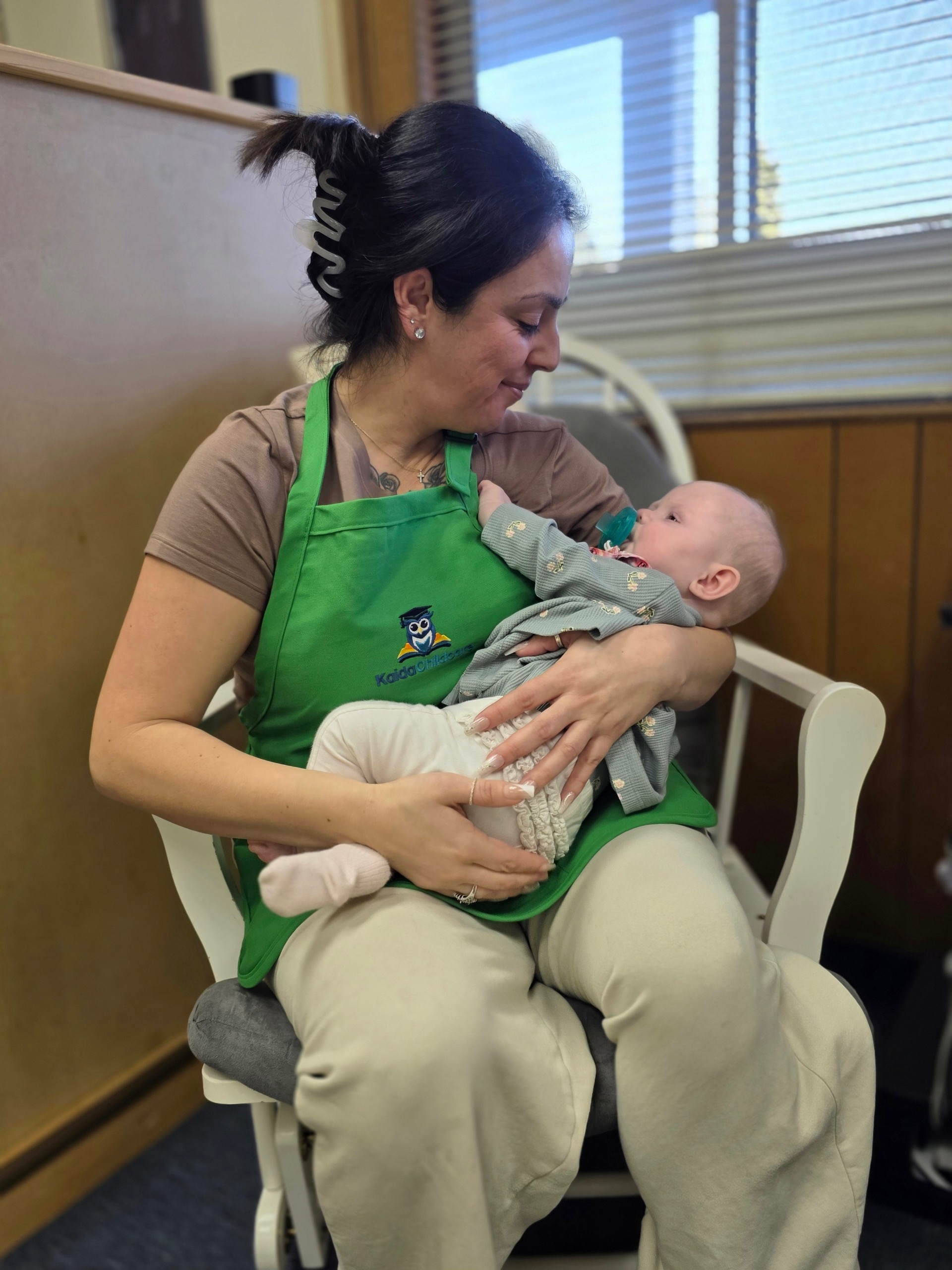 kaida-childcare-laguna-woods-infant-care-cuddling-caregiver